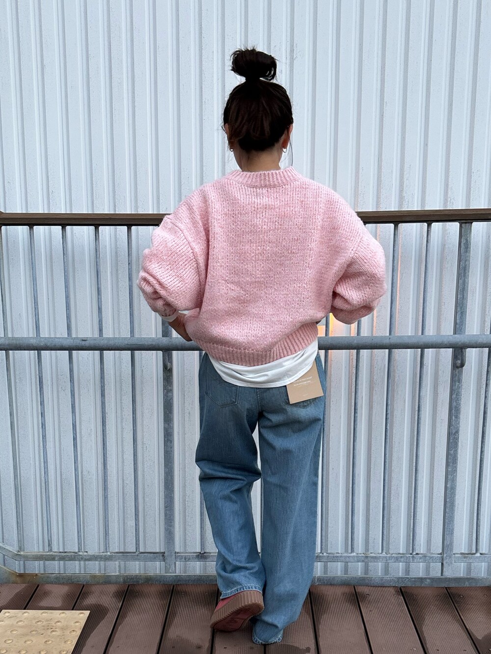 ピンク系のニット/セーター、ブルー系のデニムパンツを着用したレディースの秋コーディネートの3枚目の写真