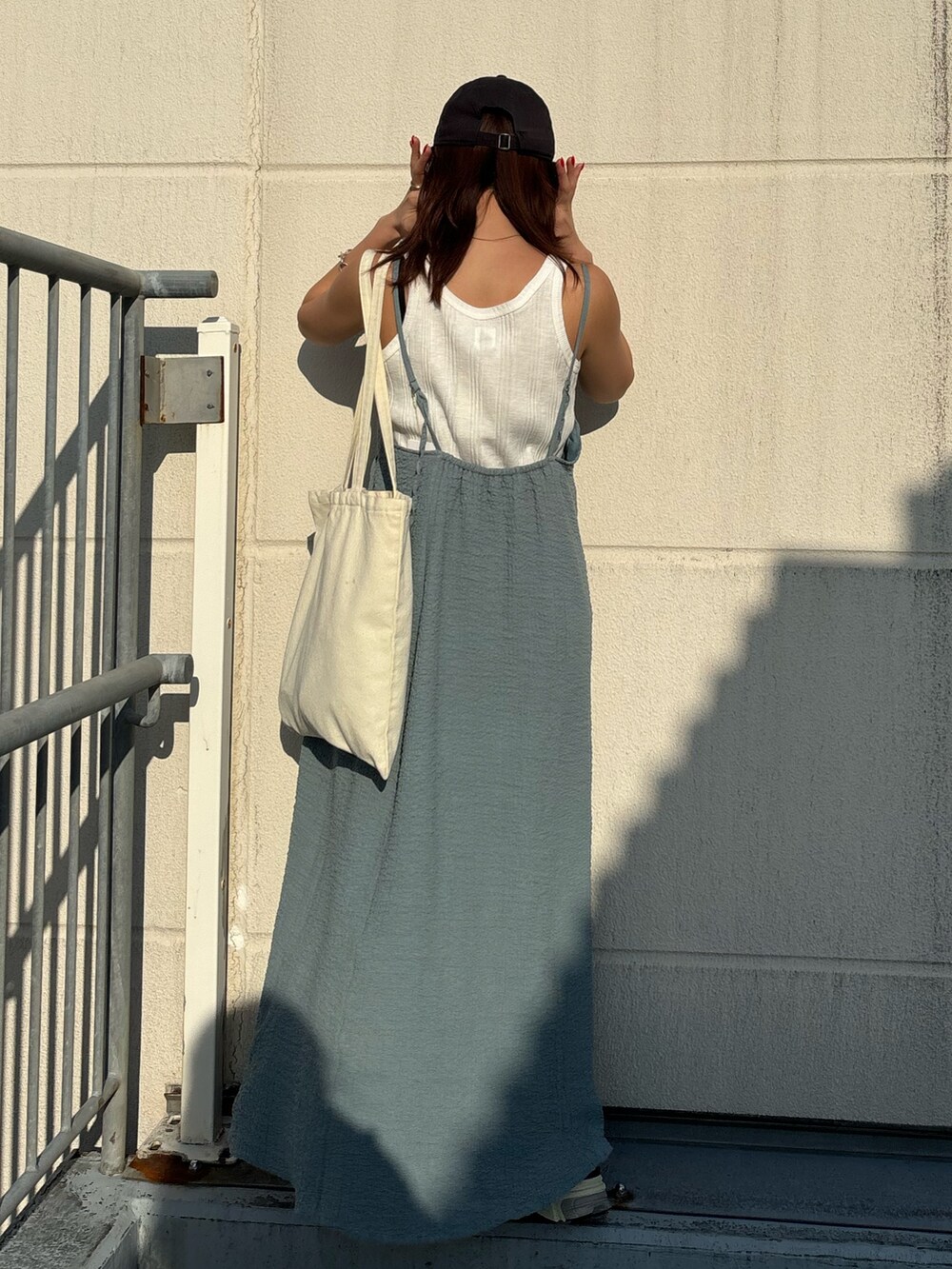 ホワイト系のタンクトップ、ブルー系のワンピース、ホワイト系のスニーカーを着用したレディースの春コーディネートの2枚目の写真