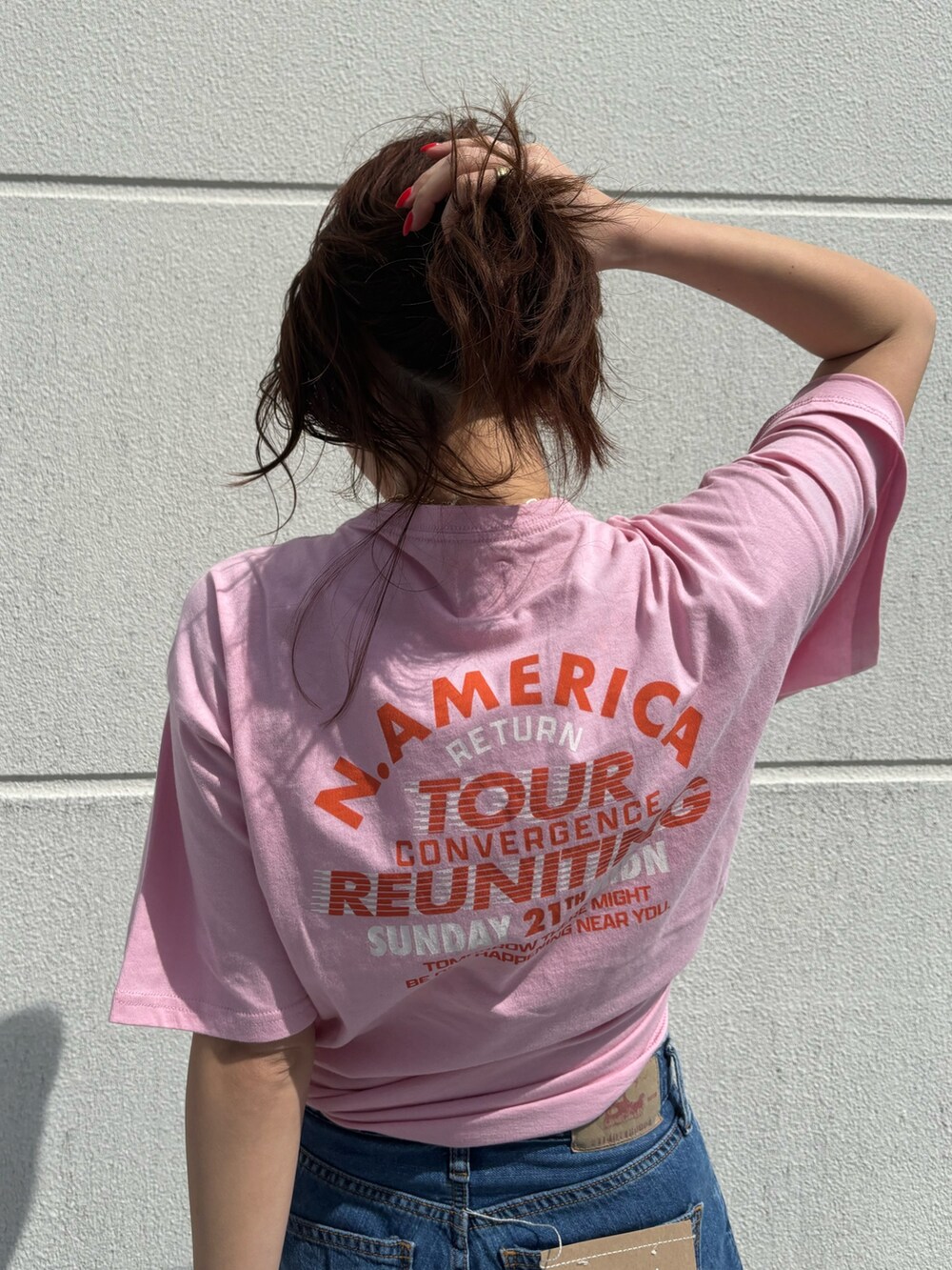 ピンク系のTシャツ/カットソー、ブルー系のデニムパンツを着用したレディースの春コーディネートの4枚目の写真