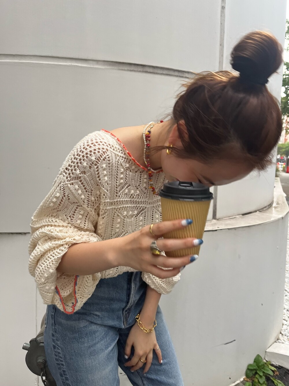 ホワイト系のニット/セーター、ブルー系のデニムパンツを着用したレディースの夏コーディネートの2枚目の写真