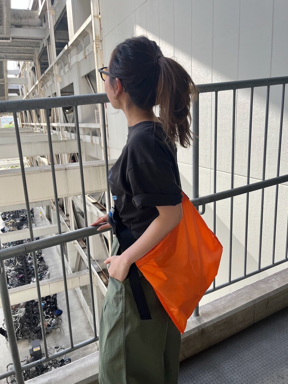 グレー系のTシャツ/カットソー、ベージュ系のその他パンツ、オレンジ系のハンドバッグを着用したレディースの春コーディネートの2枚目の写真