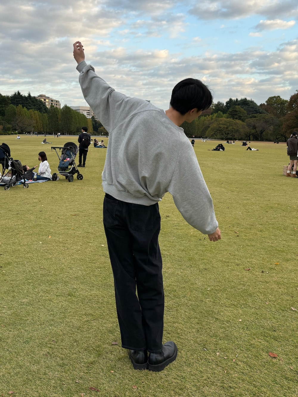 グレー系のスウェット、ブルー系のデニムパンツ、ブラック系のブーツを着用したメンズの冬コーディネートの2枚目の写真