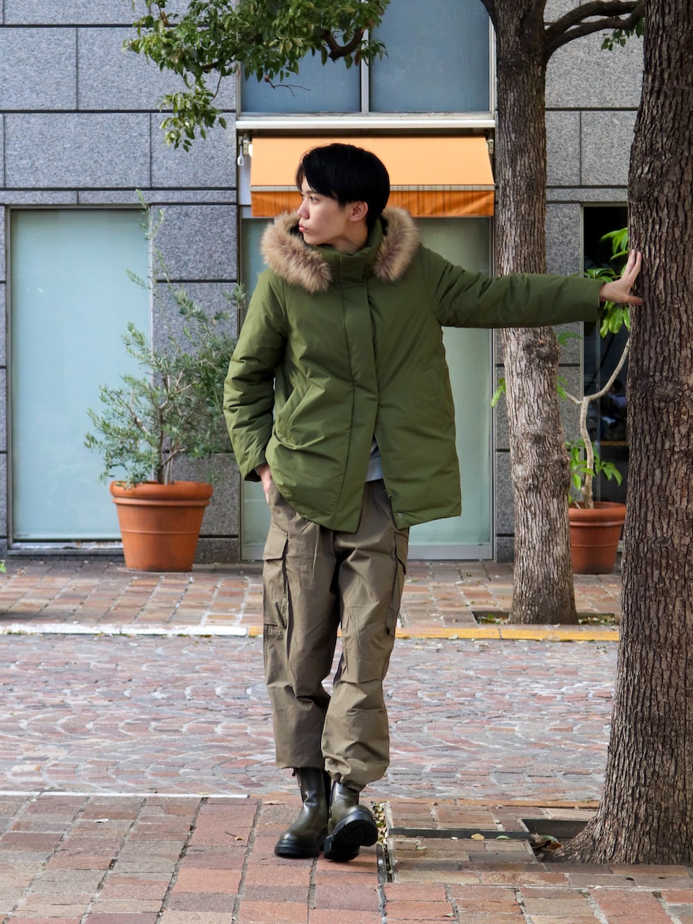 グリーン系のその他アウター、グリーン系のカーゴパンツ、ブラック系のブーツを着用したメンズの秋コーディネートの4枚目の写真