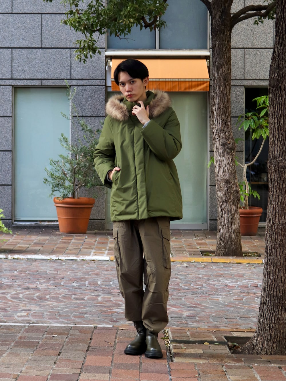 グリーン系のその他アウター、グリーン系のカーゴパンツ、ブラック系のブーツを着用したメンズの秋コーディネートの3枚目の写真