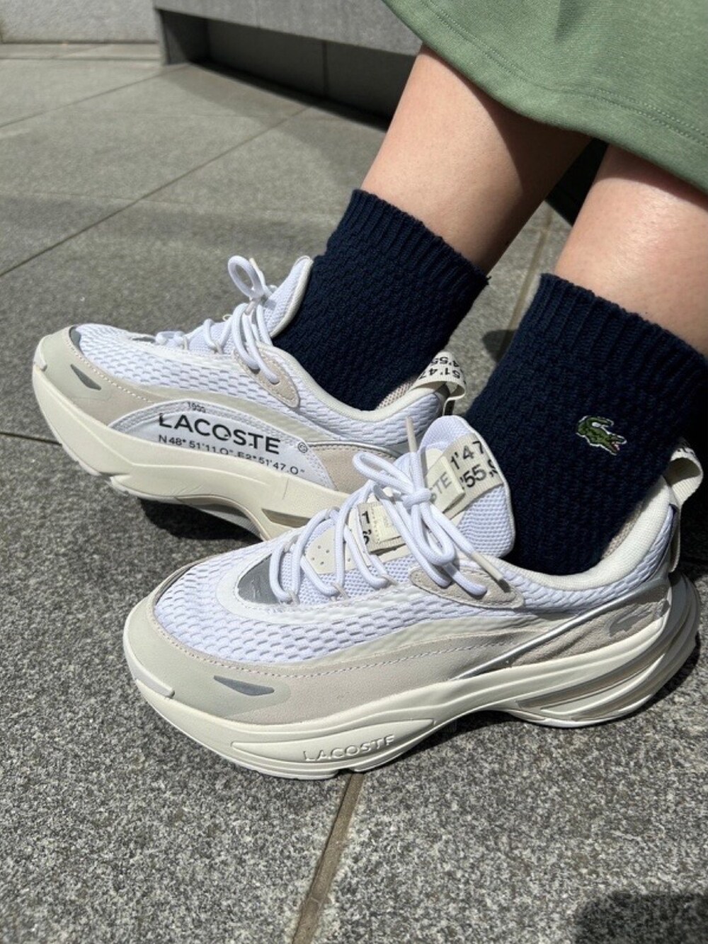 グリーン系のシャツ/ブラウス、グリーン系のワンピース、グレー系のスニーカーを着用したレディースの春コーディネートの7枚目の写真