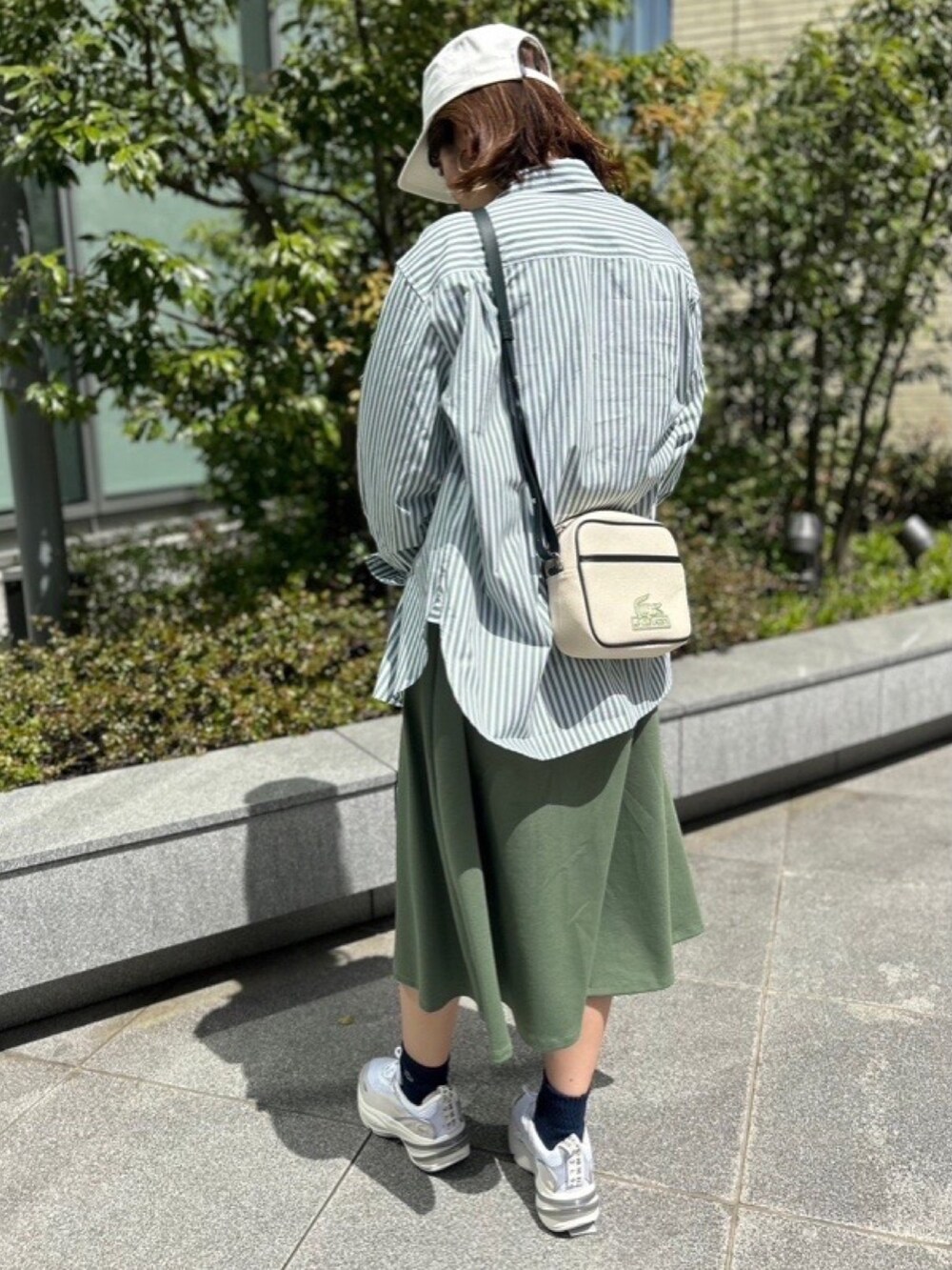 グリーン系のシャツ/ブラウス、グリーン系のワンピース、グレー系のスニーカーを着用したレディースの春コーディネートの4枚目の写真