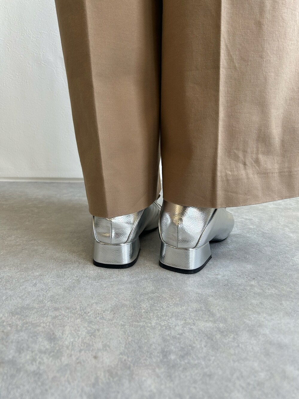 シルバー系のパンプスを着用したレディースの秋コーディネートの3枚目の写真
