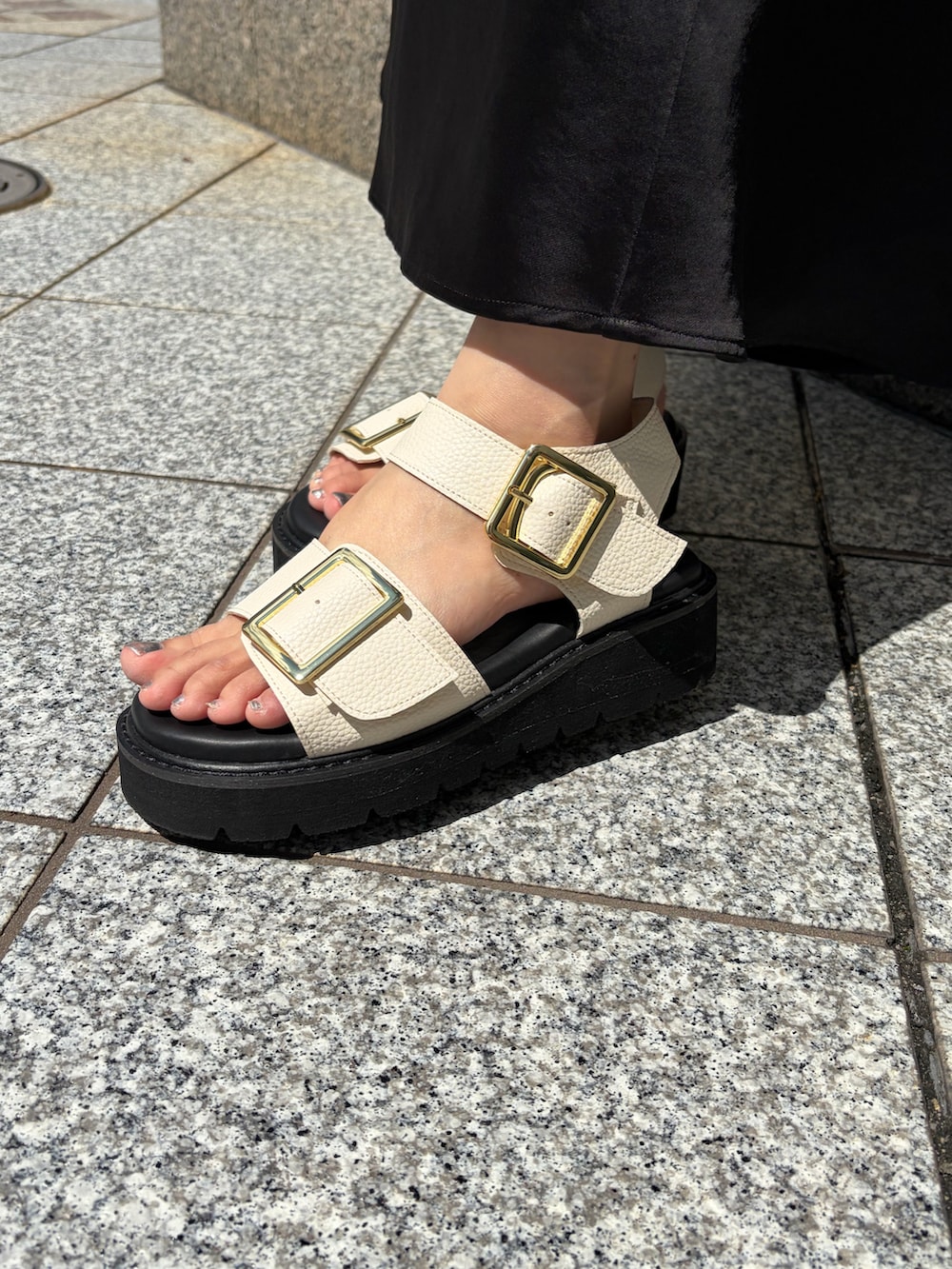ホワイト系のサンダルを着用したレディースの夏コーディネートの2枚目の写真