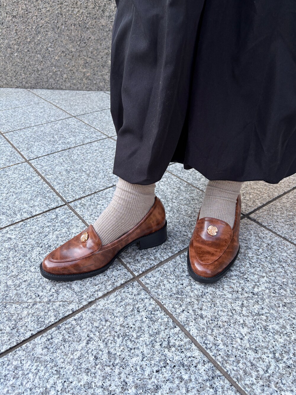 ブラウン系のローファーを着用したレディースの冬コーディネートの2枚目の写真