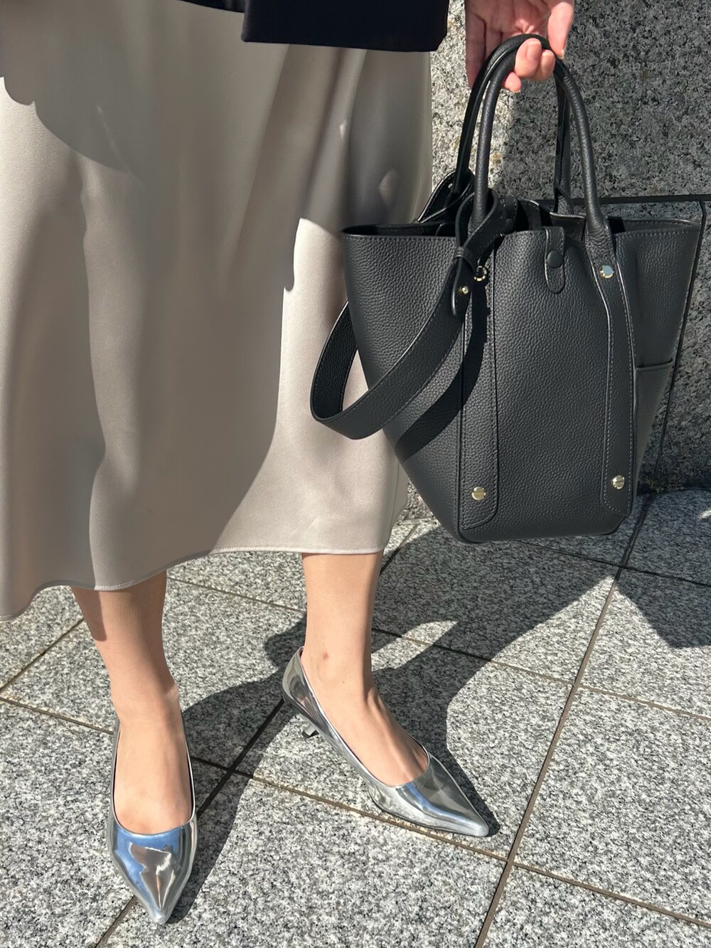 シルバー系のパンプスを着用したレディースの秋コーディネートの2枚目の写真