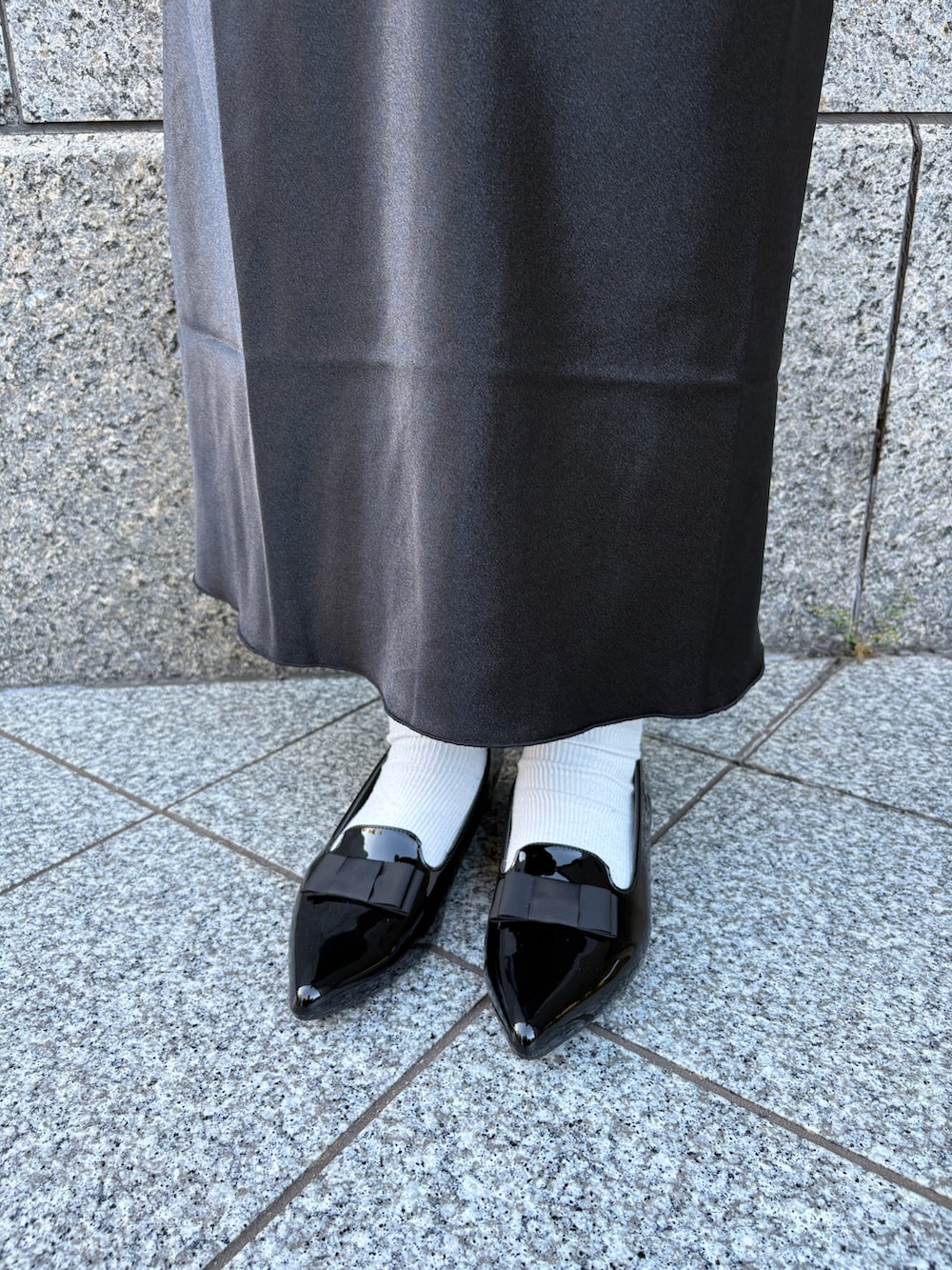 ブラック系のパンプスを着用したレディースの秋コーディネートの2枚目の写真