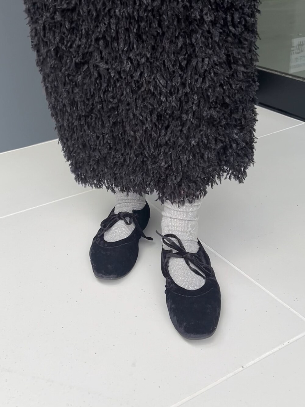 ブラック系のパンプスを着用したレディースの秋コーディネートの2枚目の写真