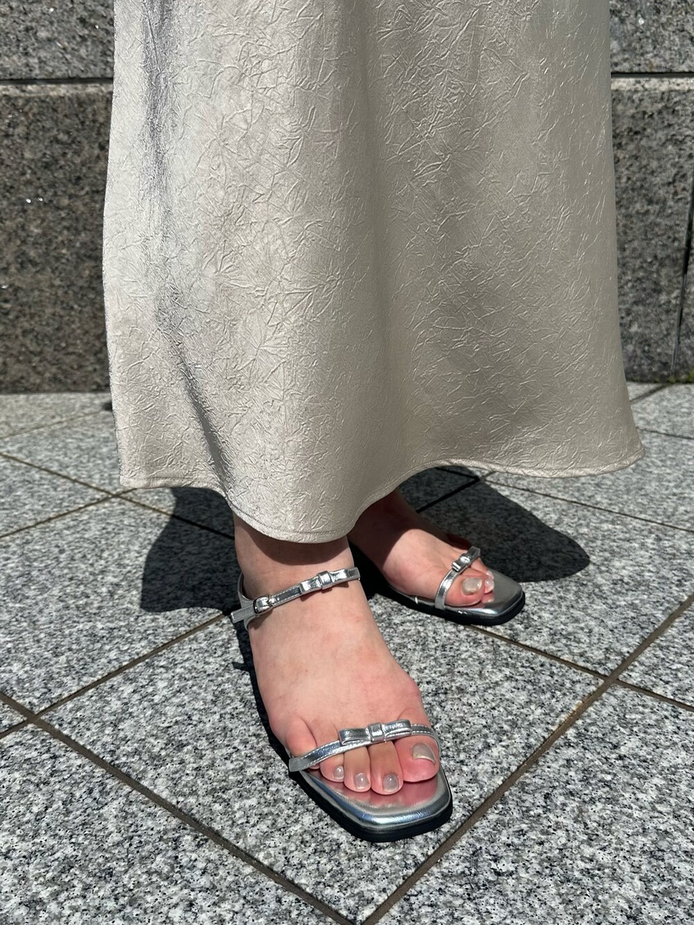 シルバー系のサンダルを着用したレディースの夏コーディネートの2枚目の写真