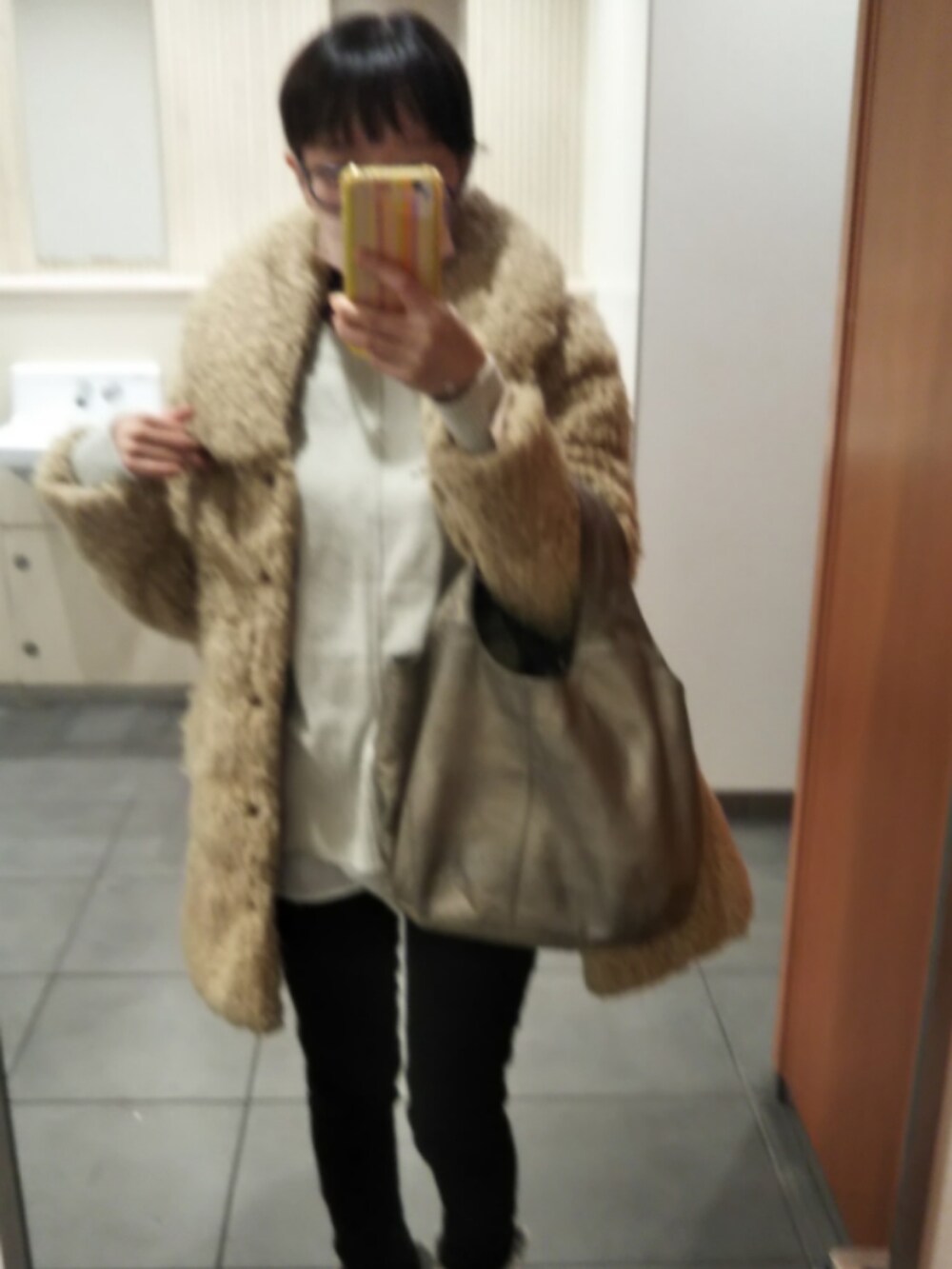 ベージュ系のダウンジャケット/コート、グレー系のニット/セーター、ブラック系のデニムパンツを着用したレディースの冬コーディネートの4枚目の写真