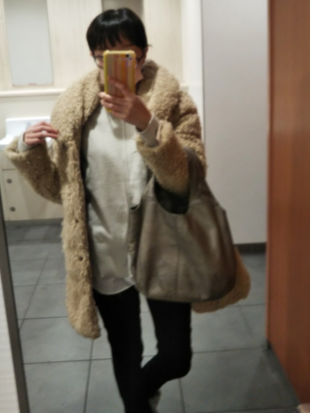 ベージュ系のダウンジャケット/コート、グレー系のニット/セーター、ブラック系のデニムパンツを着用したレディースの冬コーディネートの5枚目の写真