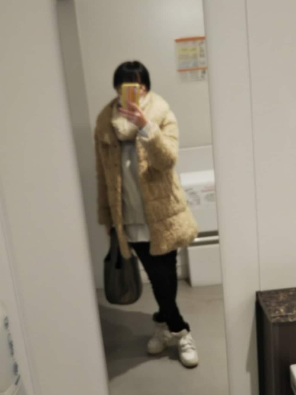 ベージュ系のダウンジャケット/コート、グレー系のニット/セーター、ブラック系のデニムパンツを着用したレディースの冬コーディネートの3枚目の写真