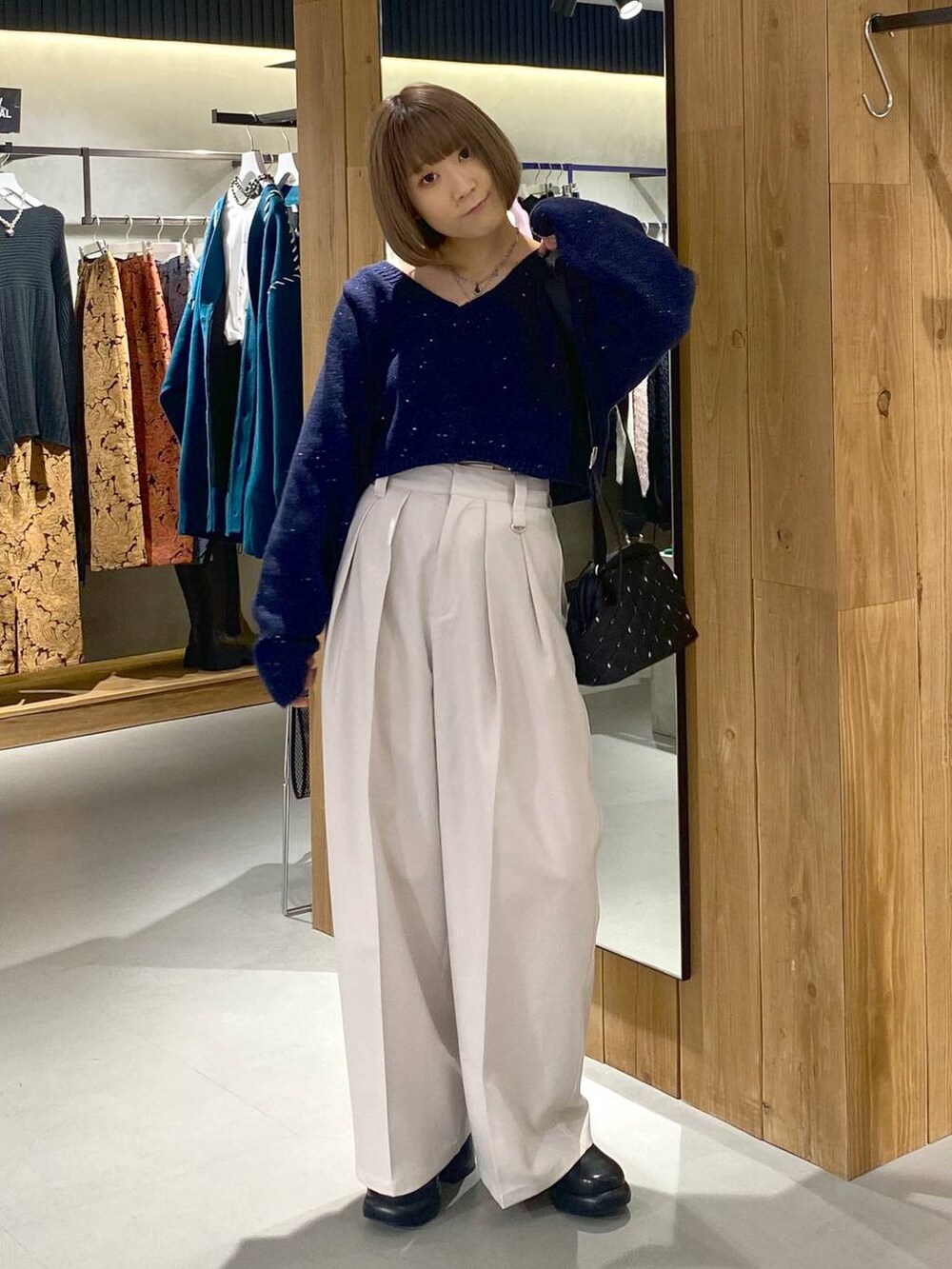 ホワイト系のキャミソール、ブラック系のブーツ、ベージュ系のスラックスを着用したレディースの冬コーディネートの4枚目の写真