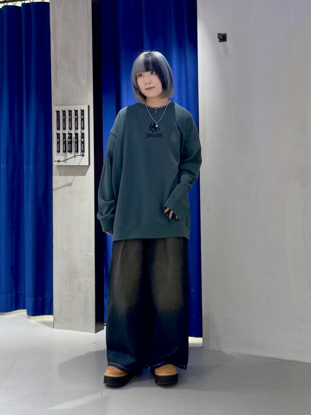 グリーン系のスウェット、ブラック系のデニムパンツ、ベージュ系のブーツを着用したレディースの冬コーディネートの4枚目の写真