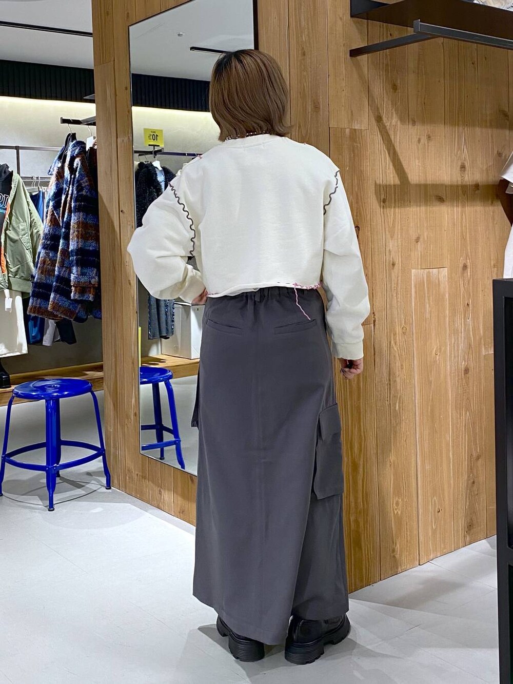 グレー系のスカート、ブラック系のその他シューズ、ホワイト系のTシャツ/カットソーを着用したレディースの冬コーディネートの2枚目の写真