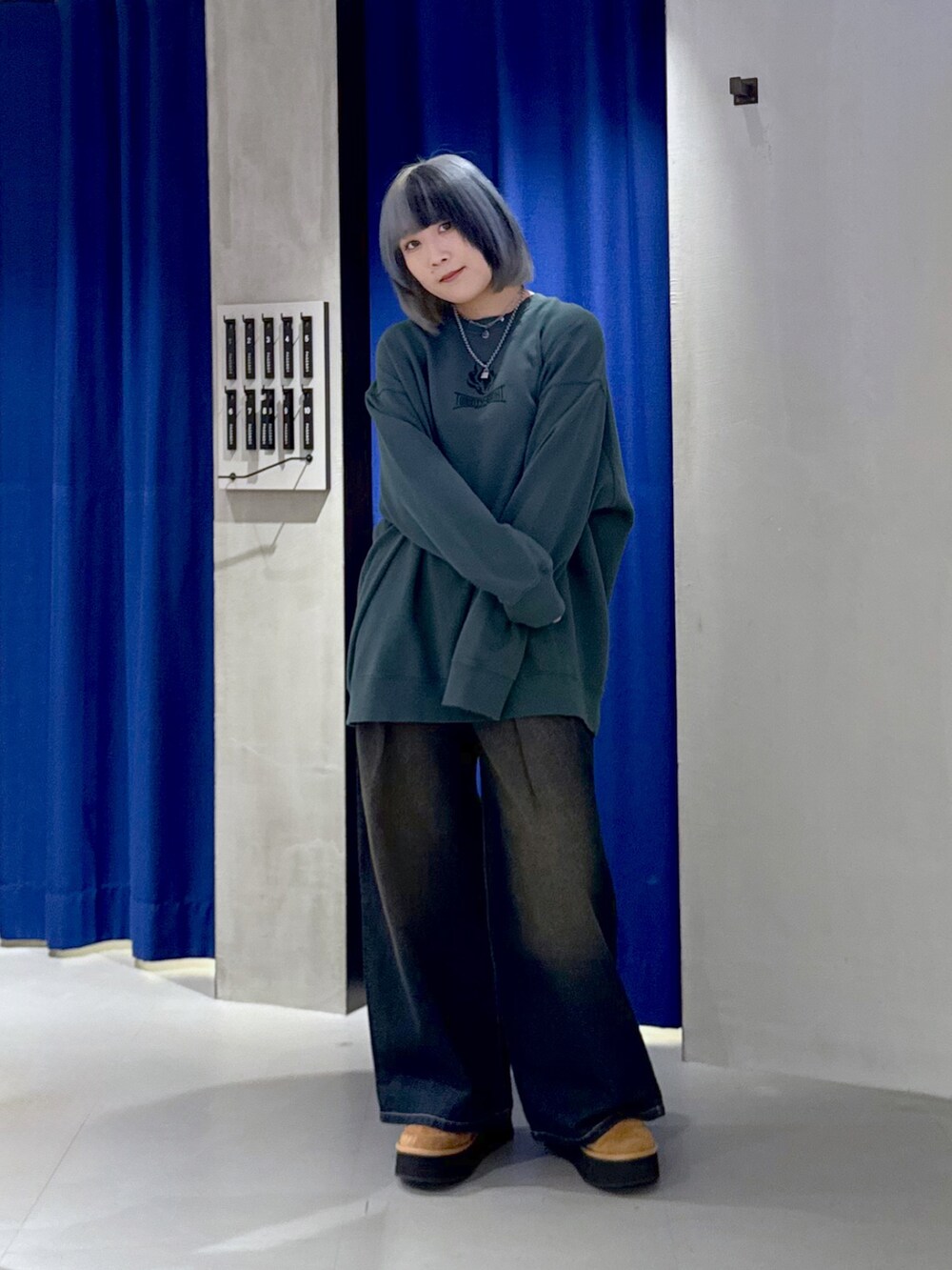 グリーン系のスウェット、ブラック系のデニムパンツ、ベージュ系のブーツを着用したレディースの冬コーディネートの2枚目の写真