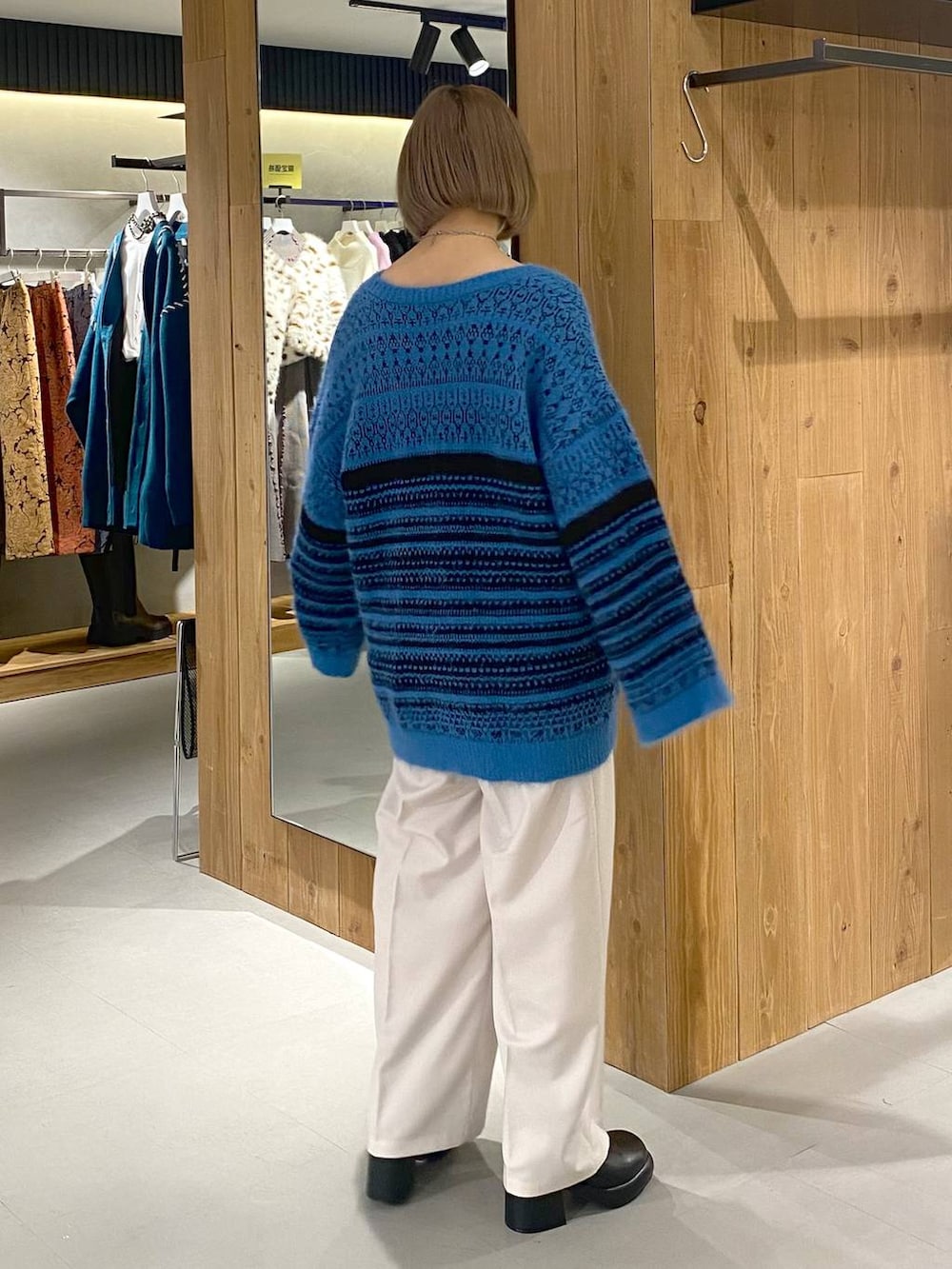 ホワイト系のキャミソール、ブラック系のブーツ、ベージュ系のスラックスを着用したレディースの冬コーディネートの3枚目の写真