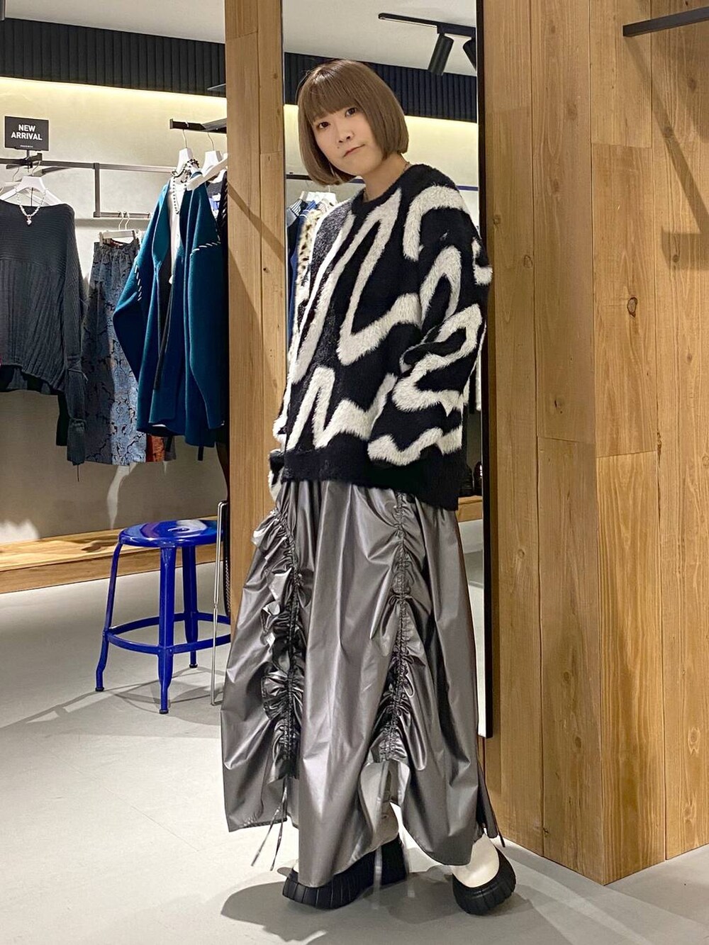 ホワイト系のブーツ、シルバー系のスカート、ブラック系のニット/セーターを着用したレディースの冬コーディネートの3枚目の写真