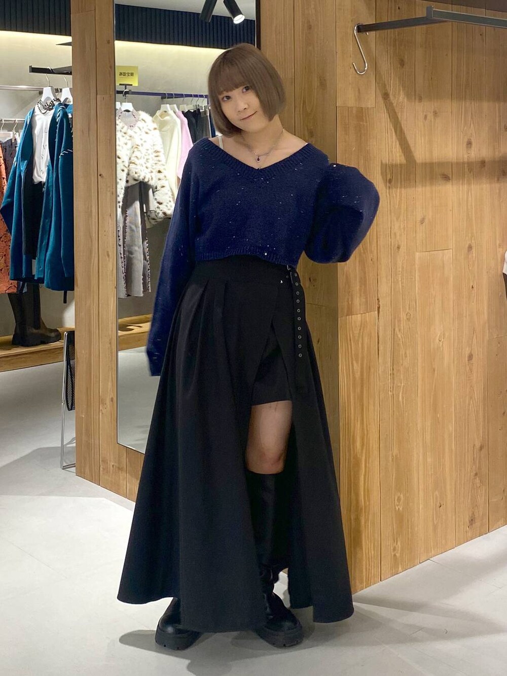 ホワイト系のキャミソール、ブラック系のブーツ、ブラック系のスカートを着用したレディースの冬コーディネートの3枚目の写真