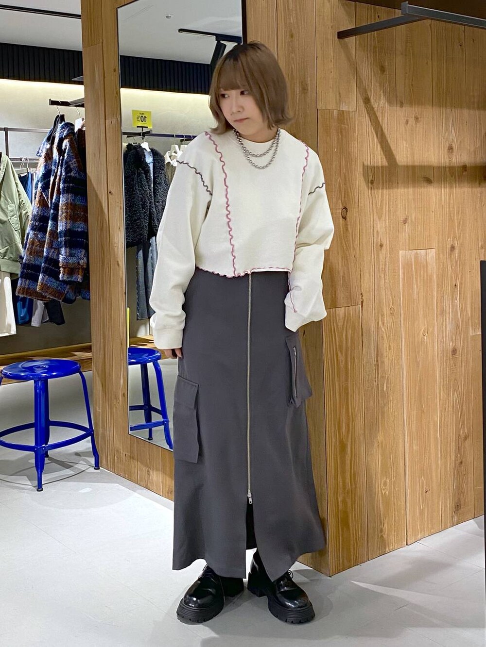 グレー系のスカート、ブラック系のその他シューズ、ホワイト系のTシャツ/カットソーを着用したレディースの冬コーディネートの3枚目の写真