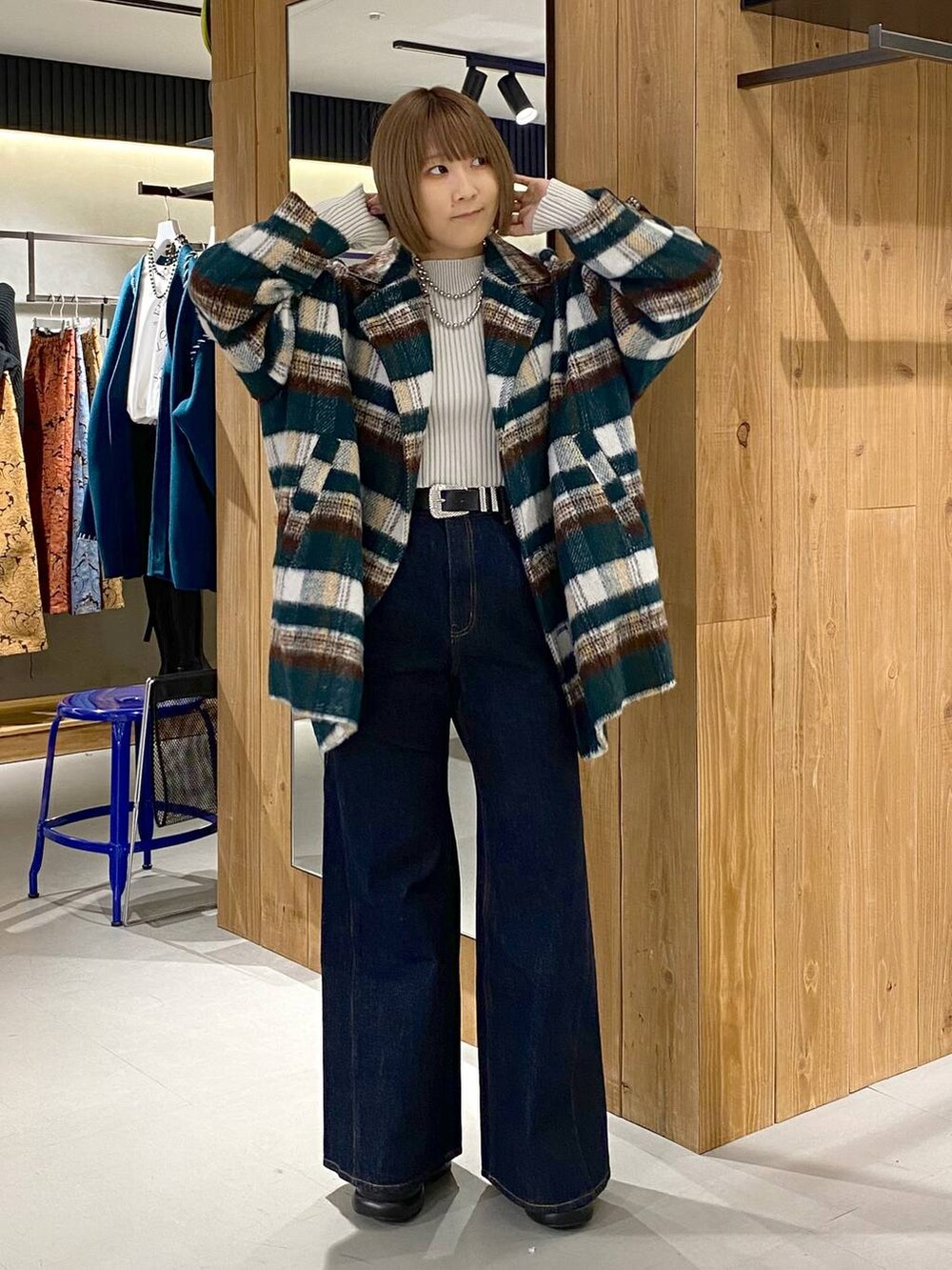 ブルー系のデニムパンツ、ブラック系のブーツ、ホワイト系のニット/セーターを着用したレディースの冬コーディネートの3枚目の写真