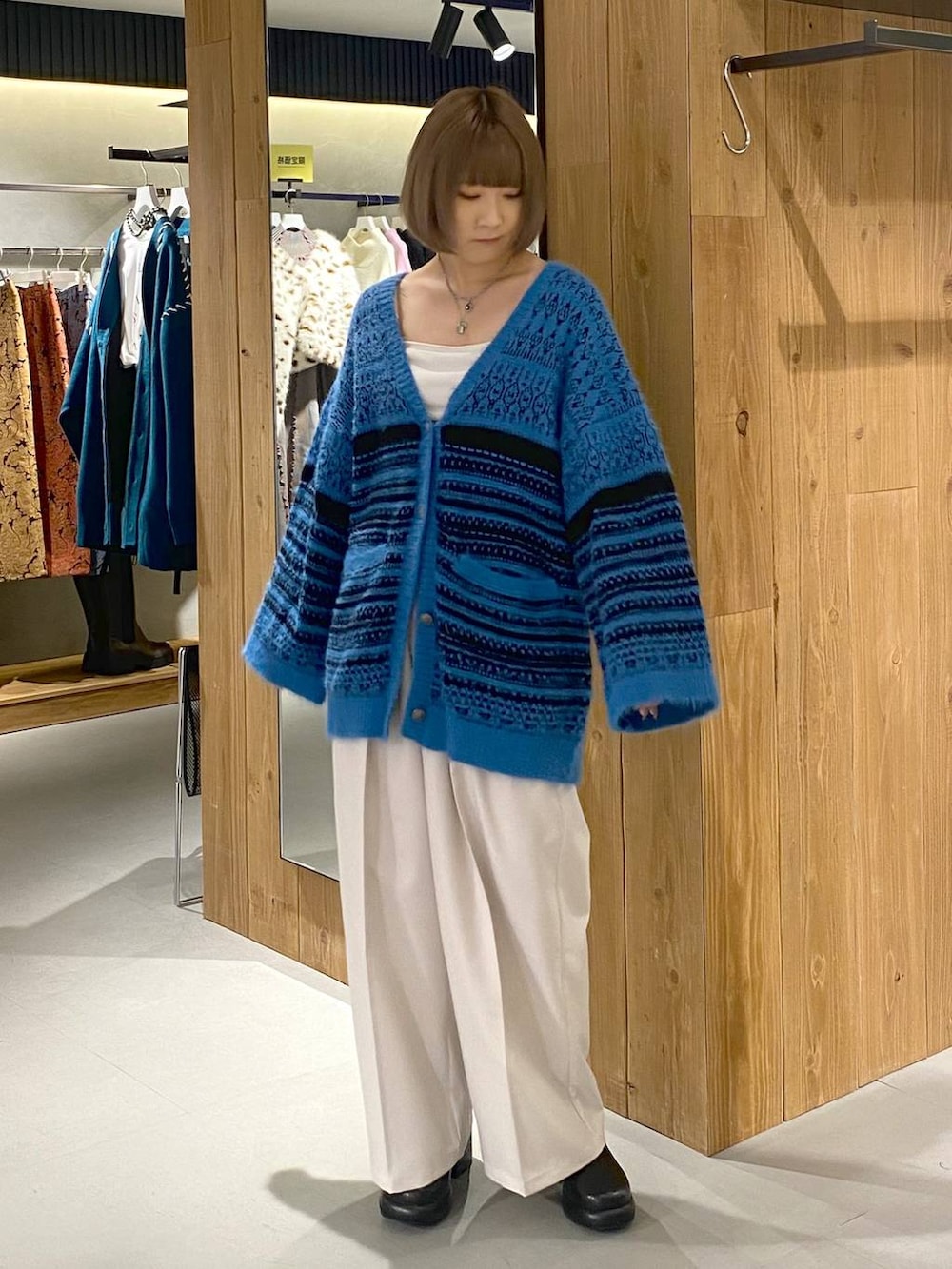 ホワイト系のキャミソール、ブラック系のブーツ、ベージュ系のスラックスを着用したレディースの冬コーディネートの4枚目の写真