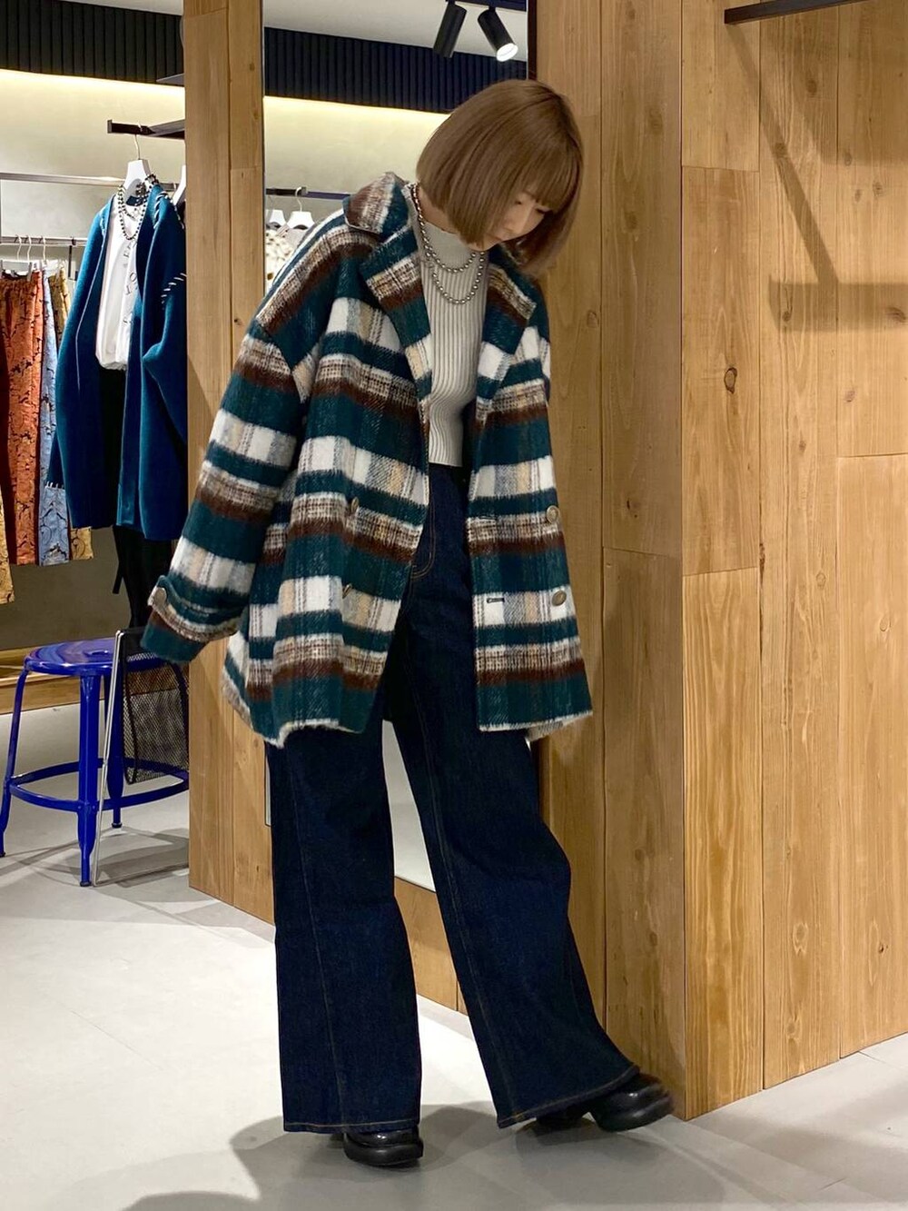 ブルー系のデニムパンツ、ブラック系のブーツ、ホワイト系のニット/セーターを着用したレディースの冬コーディネートの4枚目の写真