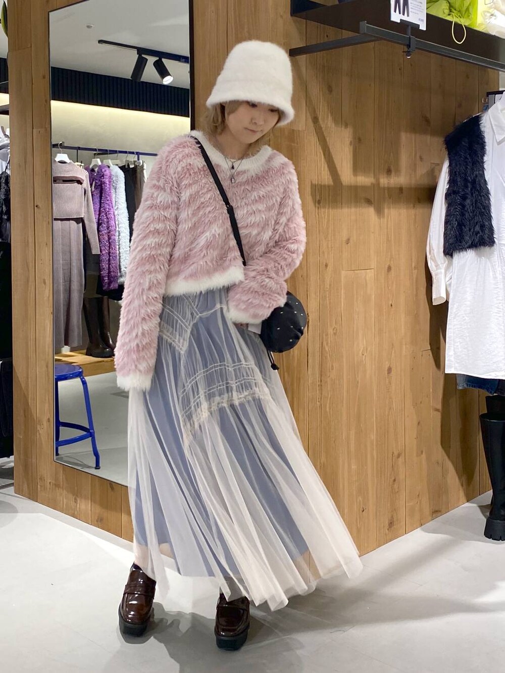 ブラック系のローファー、ブラック系のショルダーバッグ、ピンク系のカーディガン/ボレロを着用したレディースの秋コーディネートの2枚目の写真