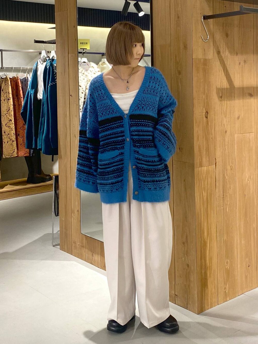 ホワイト系のキャミソール、ブラック系のブーツ、ベージュ系のスラックスを着用したレディースの冬コーディネートの5枚目の写真