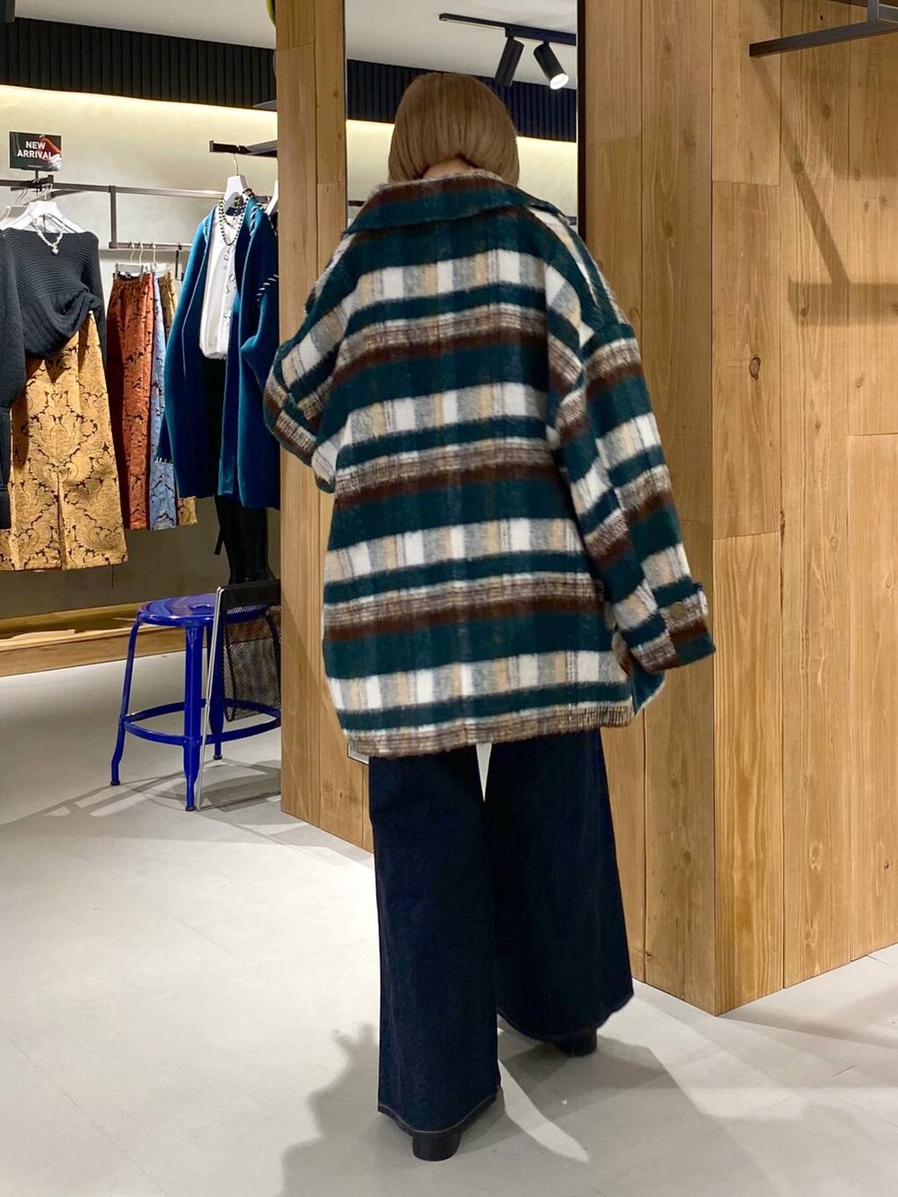 ブルー系のデニムパンツ、ブラック系のブーツ、ホワイト系のニット/セーターを着用したレディースの冬コーディネートの5枚目の写真