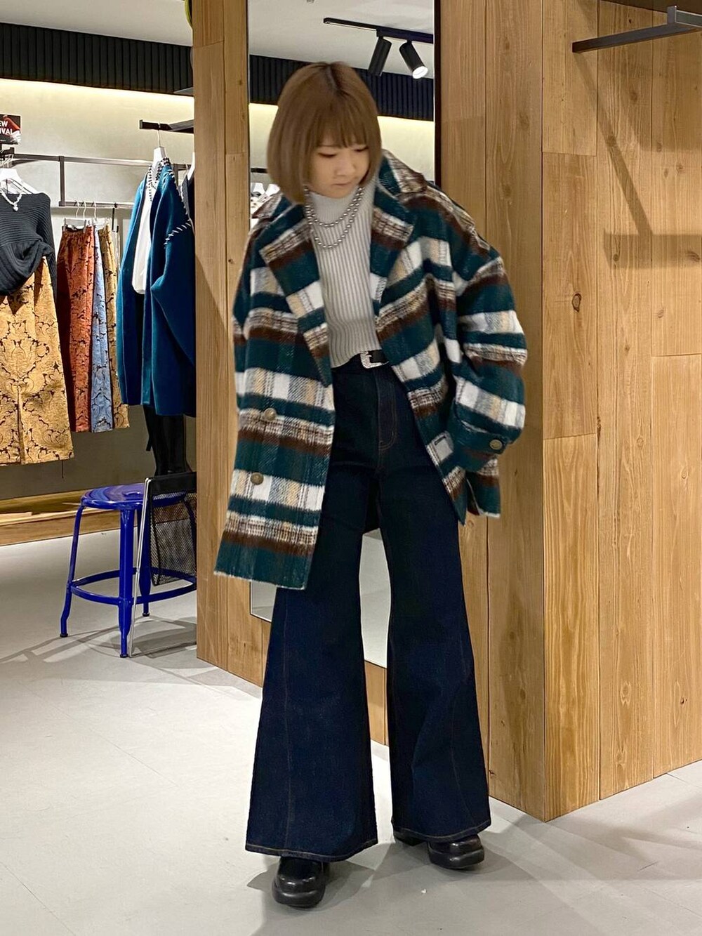 ブルー系のデニムパンツ、ブラック系のブーツ、ホワイト系のニット/セーターを着用したレディースの冬コーディネートの2枚目の写真