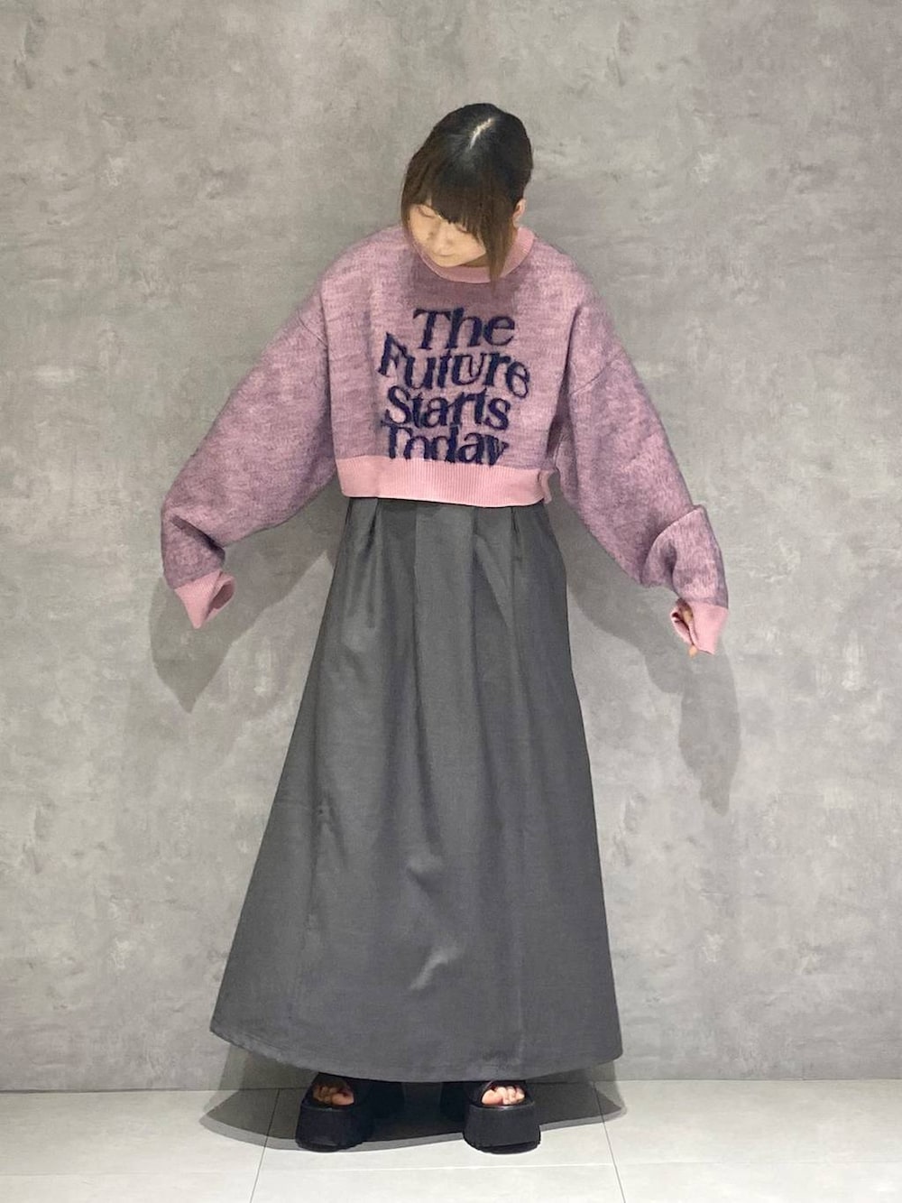 ブラック系のサンダル、ピンク系のニット/セーター、グレー系のジャンパースカートを着用したレディースの秋コーディネートの4枚目の写真