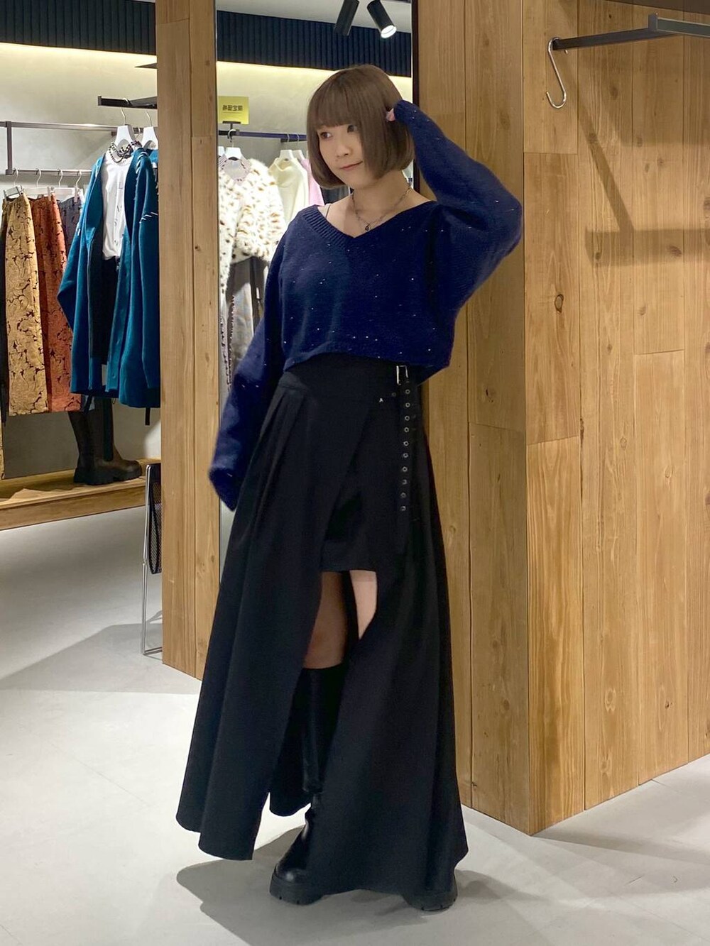 ホワイト系のキャミソール、ブラック系のブーツ、ブラック系のスカートを着用したレディースの冬コーディネートの4枚目の写真