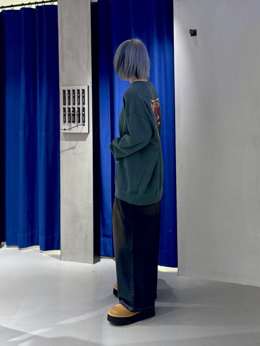 グリーン系のスウェット、ブラック系のデニムパンツ、ベージュ系のブーツを着用したレディースの冬コーディネートの3枚目の写真