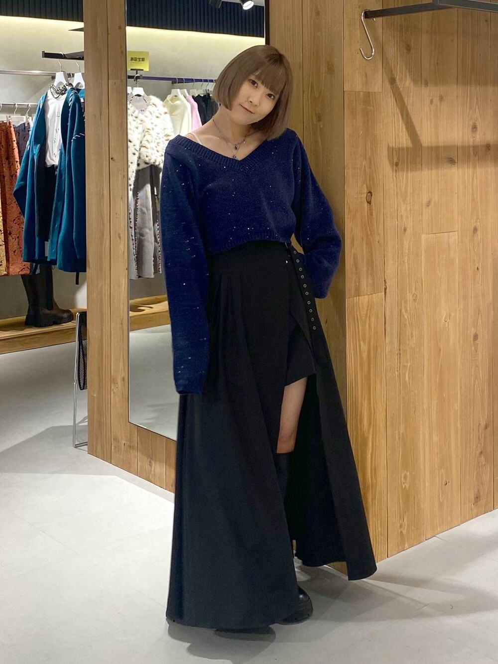 ホワイト系のキャミソール、ブラック系のブーツ、ブラック系のスカートを着用したレディースの冬コーディネートの2枚目の写真