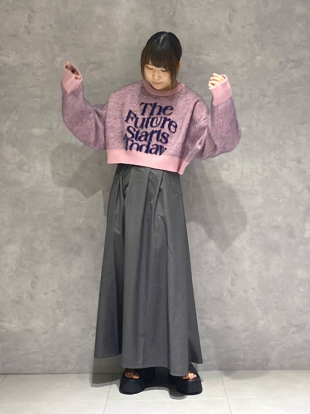 ブラック系のサンダル、ピンク系のニット/セーター、グレー系のジャンパースカートを着用したレディースの秋コーディネートの2枚目の写真