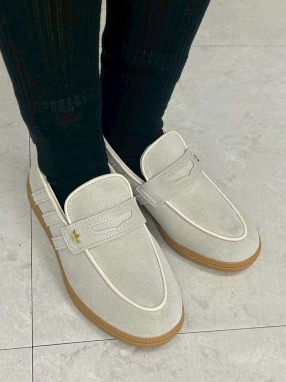 ブラック系のスカート、ブラック系のショルダーバッグ、ブルー系のポロシャツを着用したレディースの冬コーディネートの4枚目の写真