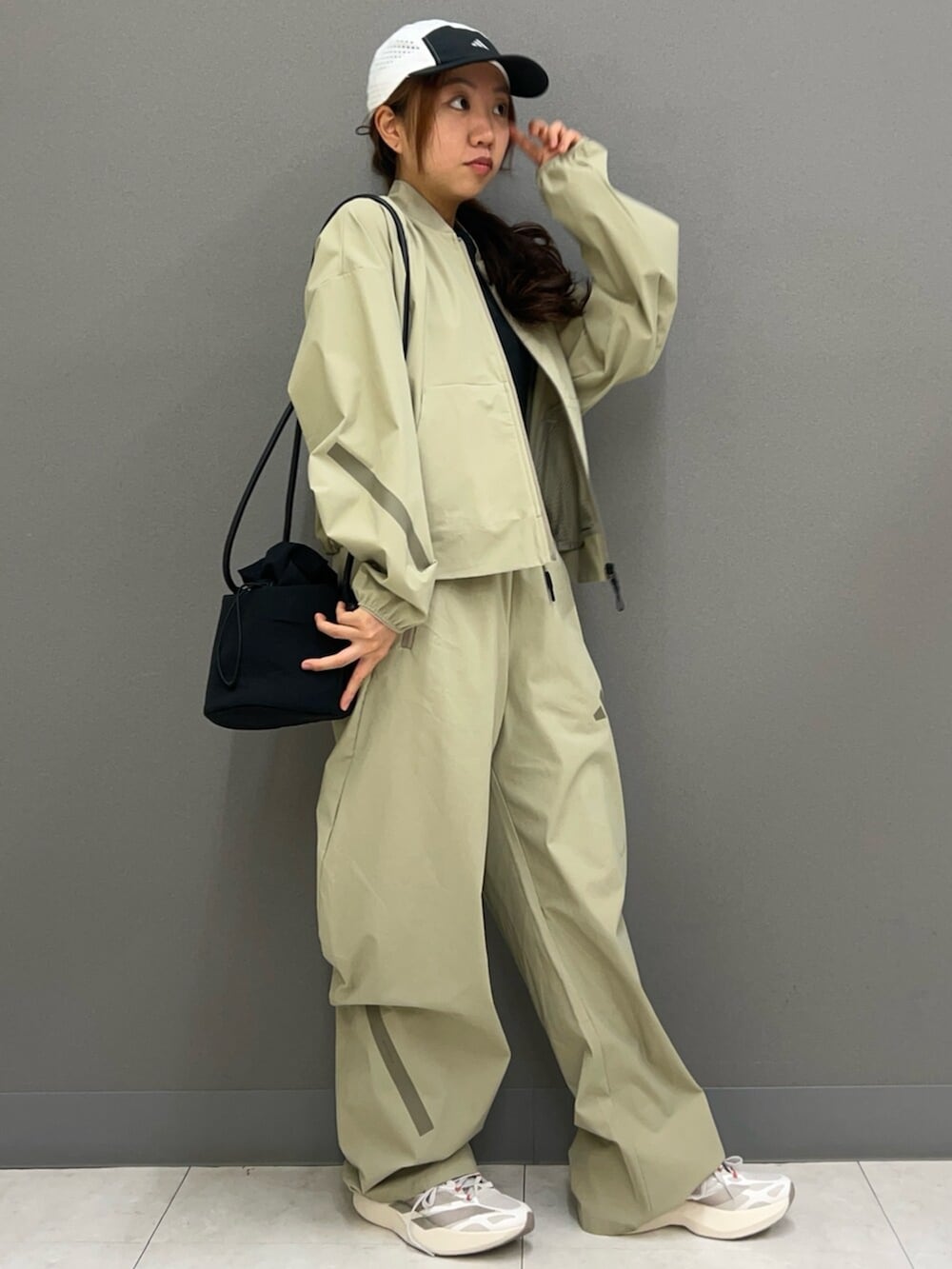 ベージュ系のMA-1、ブラック系のタンクトップ、グリーン系のスウェットパンツを着用したレディースの春コーディネートの2枚目の写真