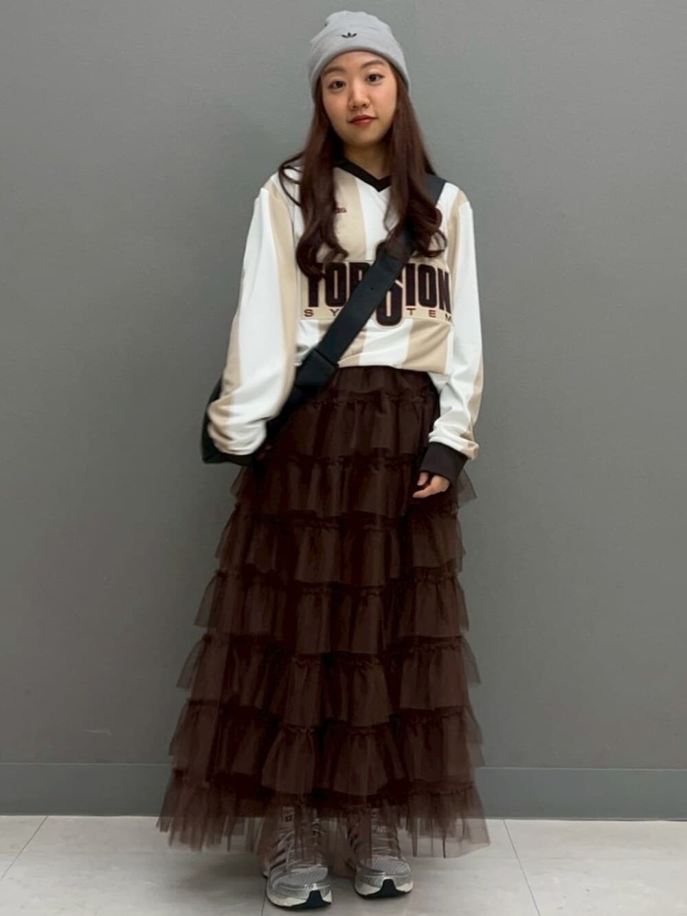 ホワイト系のトップス、シルバー系のスニーカー、ブラック系のショルダーバッグを着用したレディースの冬コーディネートの3枚目の写真