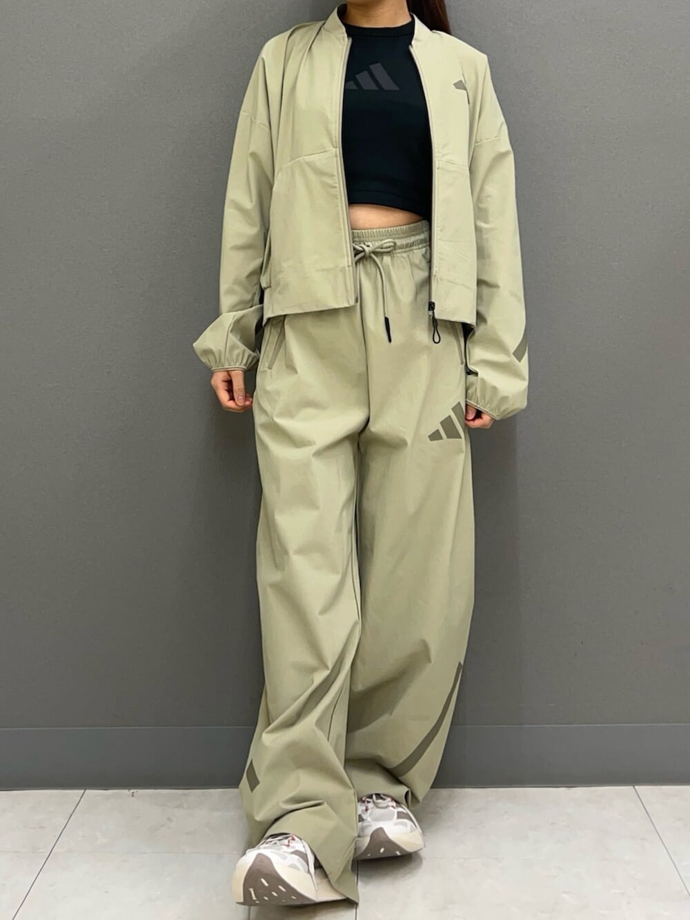 ベージュ系のMA-1、ブラック系のタンクトップ、グリーン系のスウェットパンツを着用したレディースの春コーディネートの4枚目の写真