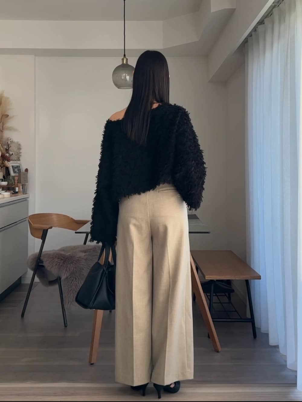 ブラック系のニット/セーター、ベージュ系のその他パンツを着用したレディースの春コーディネートの3枚目の写真