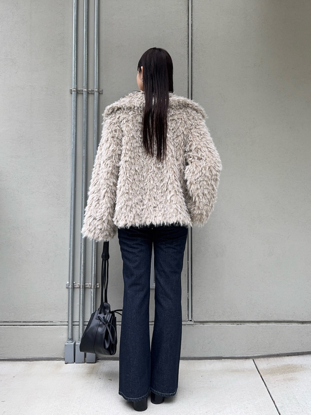 ベージュ系のその他アウター、ブルー系のデニムパンツ、ブラック系のショルダーバッグを着用したレディースの秋コーディネートの3枚目の写真