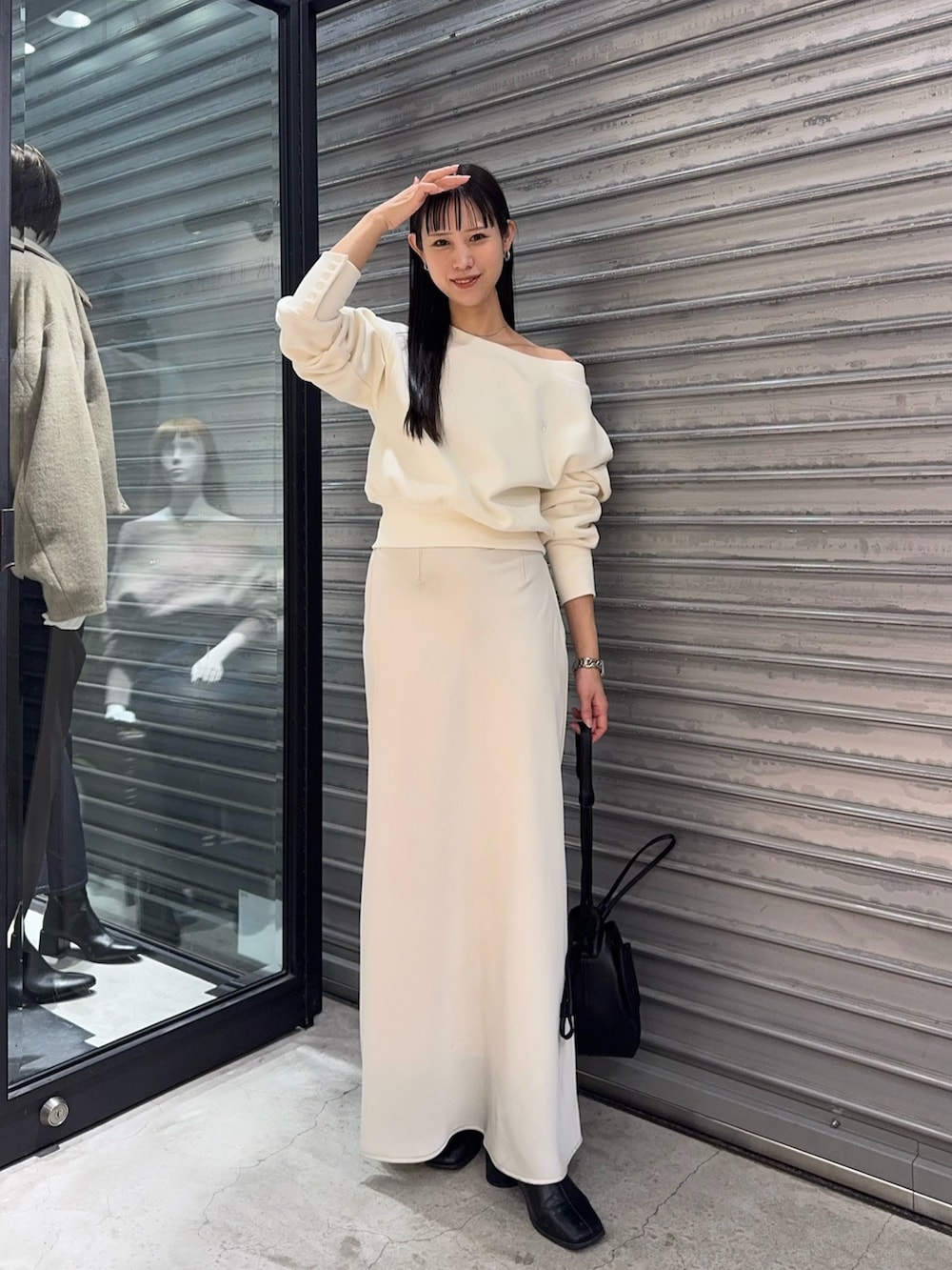 ホワイト系のTシャツ/カットソー、ホワイト系のスカート、ブラック系のショルダーバッグを着用したレディースの秋コーディネートの2枚目の写真