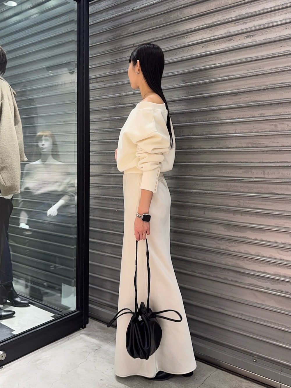 ホワイト系のTシャツ/カットソー、ホワイト系のスカート、ブラック系のショルダーバッグを着用したレディースの秋コーディネートの3枚目の写真