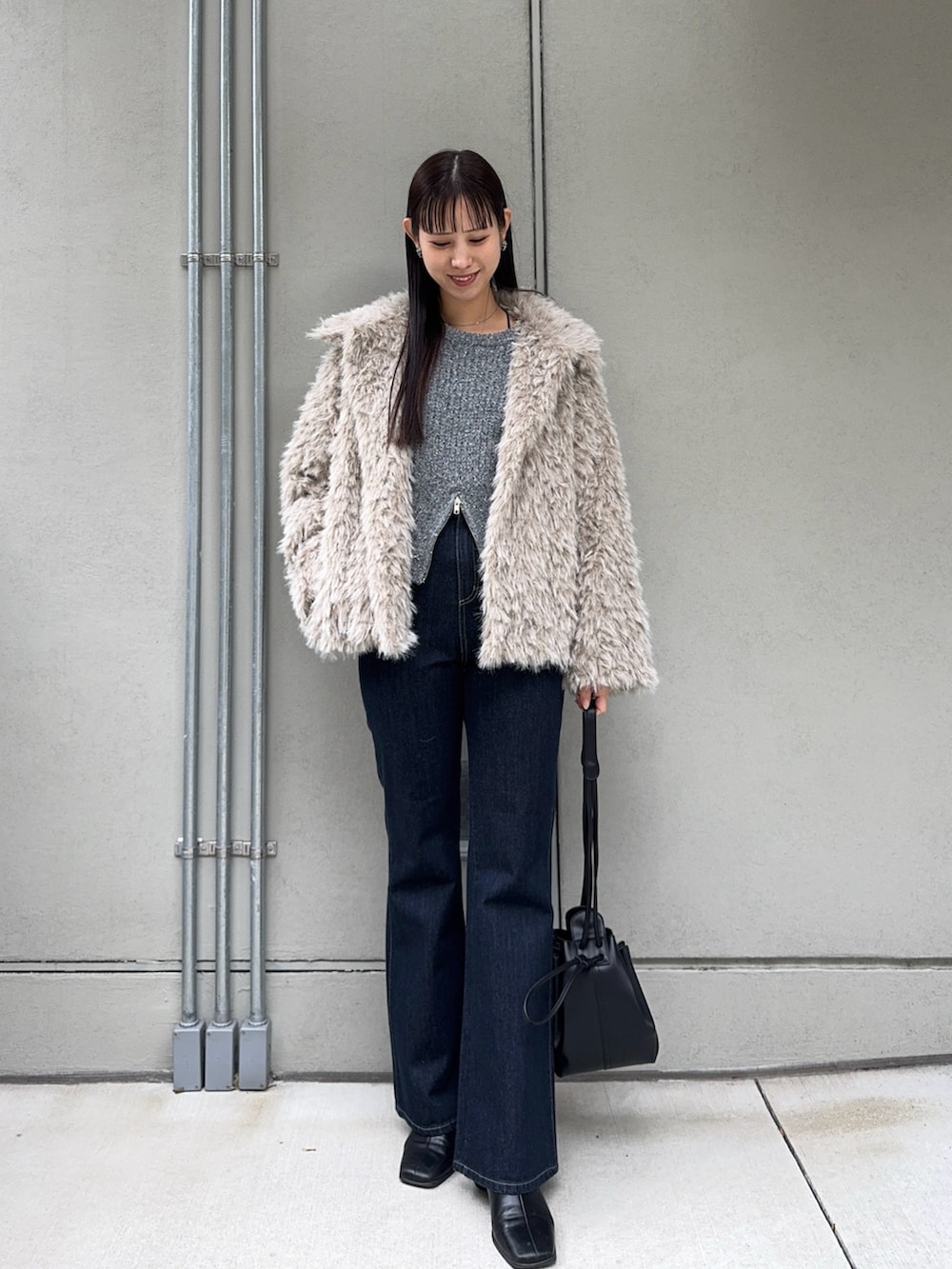 ベージュ系のその他アウター、ブルー系のデニムパンツ、ブラック系のショルダーバッグを着用したレディースの秋コーディネートの4枚目の写真