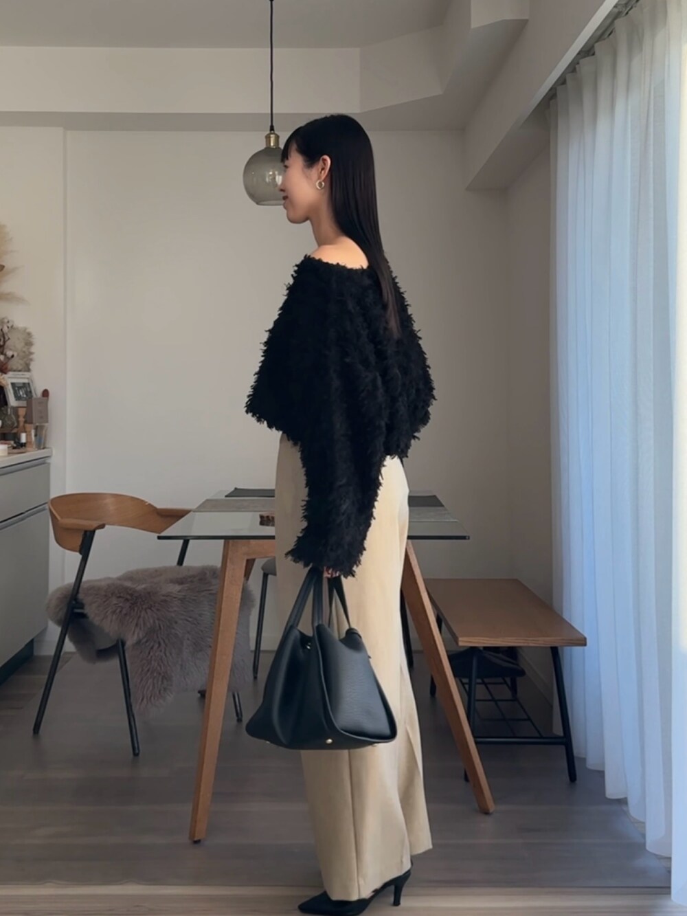 ブラック系のニット/セーター、ベージュ系のその他パンツを着用したレディースの春コーディネートの2枚目の写真